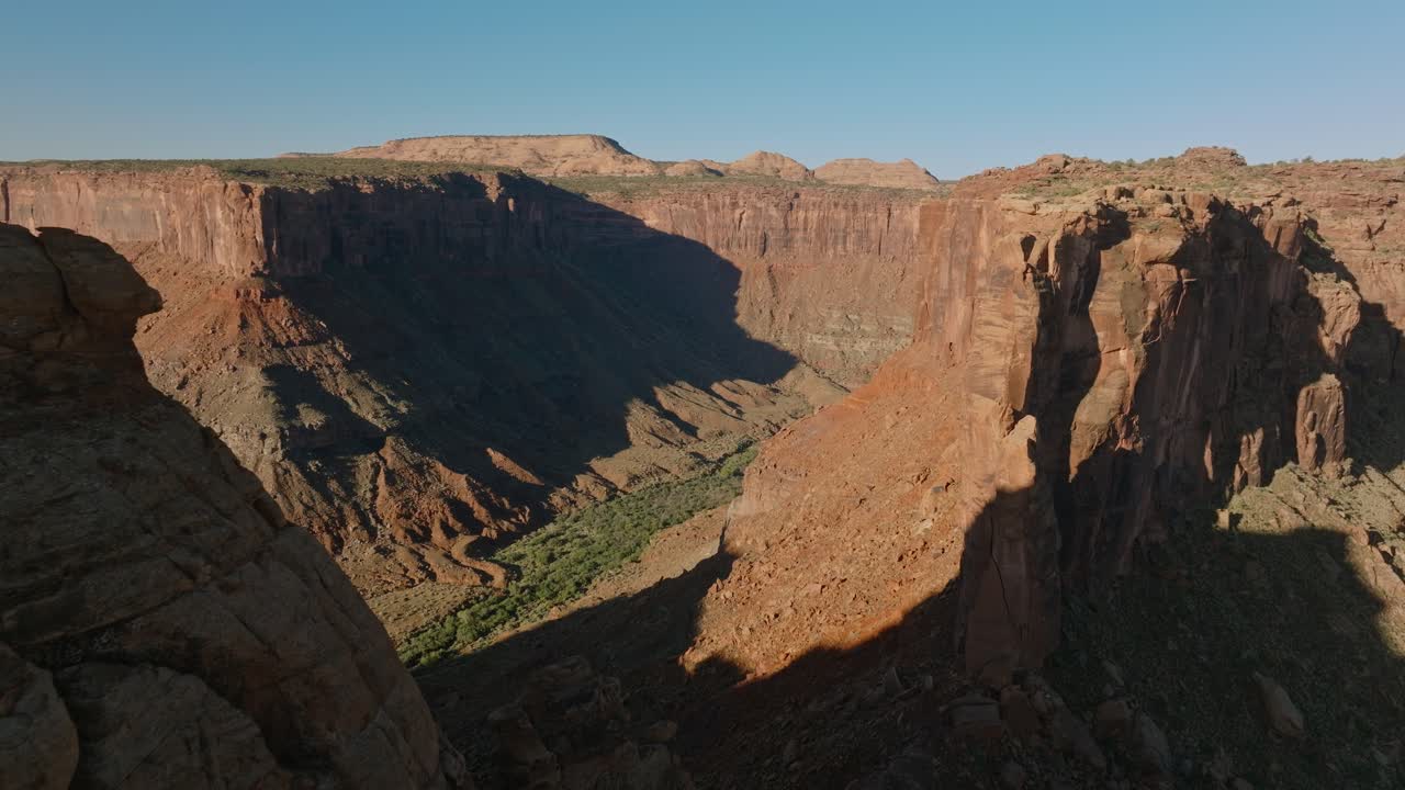 Dramatic aerial view of canyon cliffs in Moab, USA, under clear blue sky