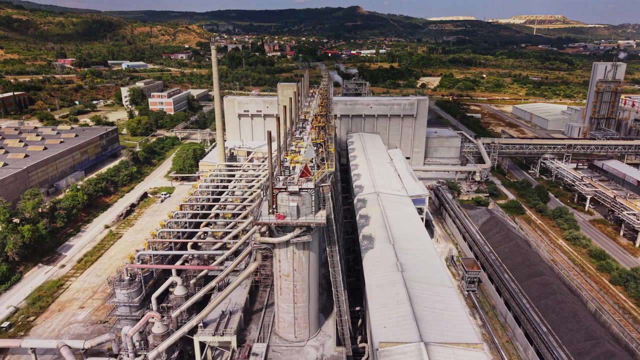 Industrial plant near a mountain range with machinery and processing areas