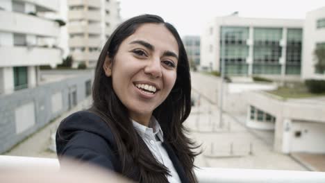 Happy-businesswoman-talking-and-smiling-at-camera