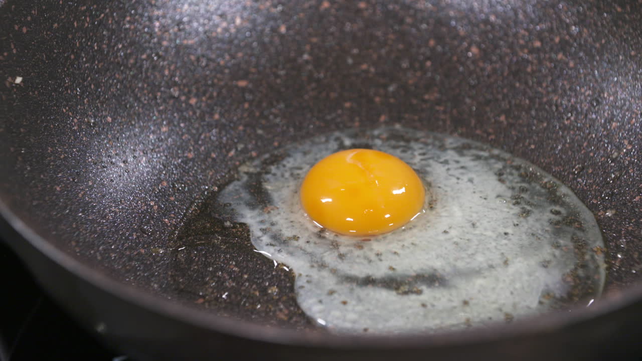 Crack an Egg, Making Fried Egg in a Black Pan, Fried Eggs, Egg Yolk and Egg White