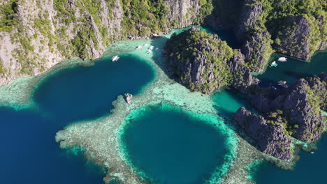 drone view of philippines, coron island’s untouched coastline, surrounded by lush forests and clear waters. revealing aerial view of bungalows and lagoon.