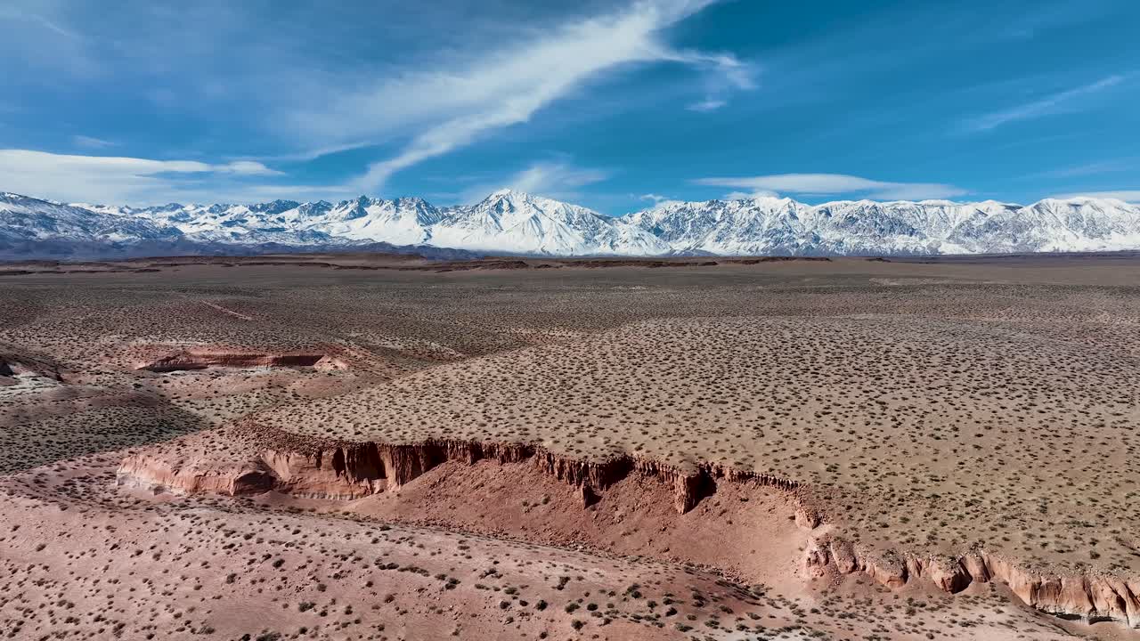 video aéreo de acantilados rojos en las mesetas volcánicas con fondo de sierra nevada cerca de bishop, california