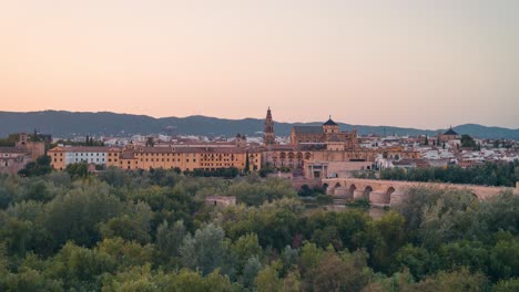 Sunset-panoramic-view-zoom-in-day-to-night-timelapse-of-Cordoba-city-Mezquita-Mosque-cathedral-and-roman-bridge-during-summer