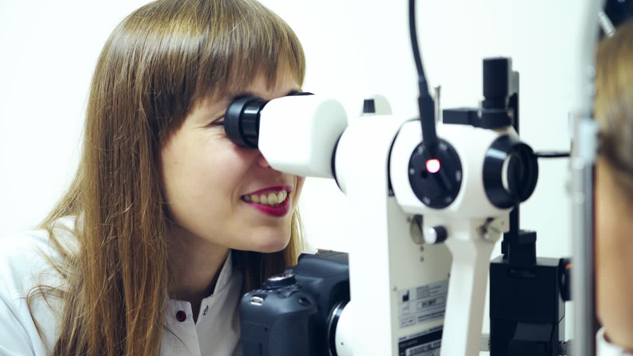 Female doctor checking patient's eyes. Medical ophthalmic device for eye examination. Optometrist diagnoses eyes by biomicroscope in clinic.
