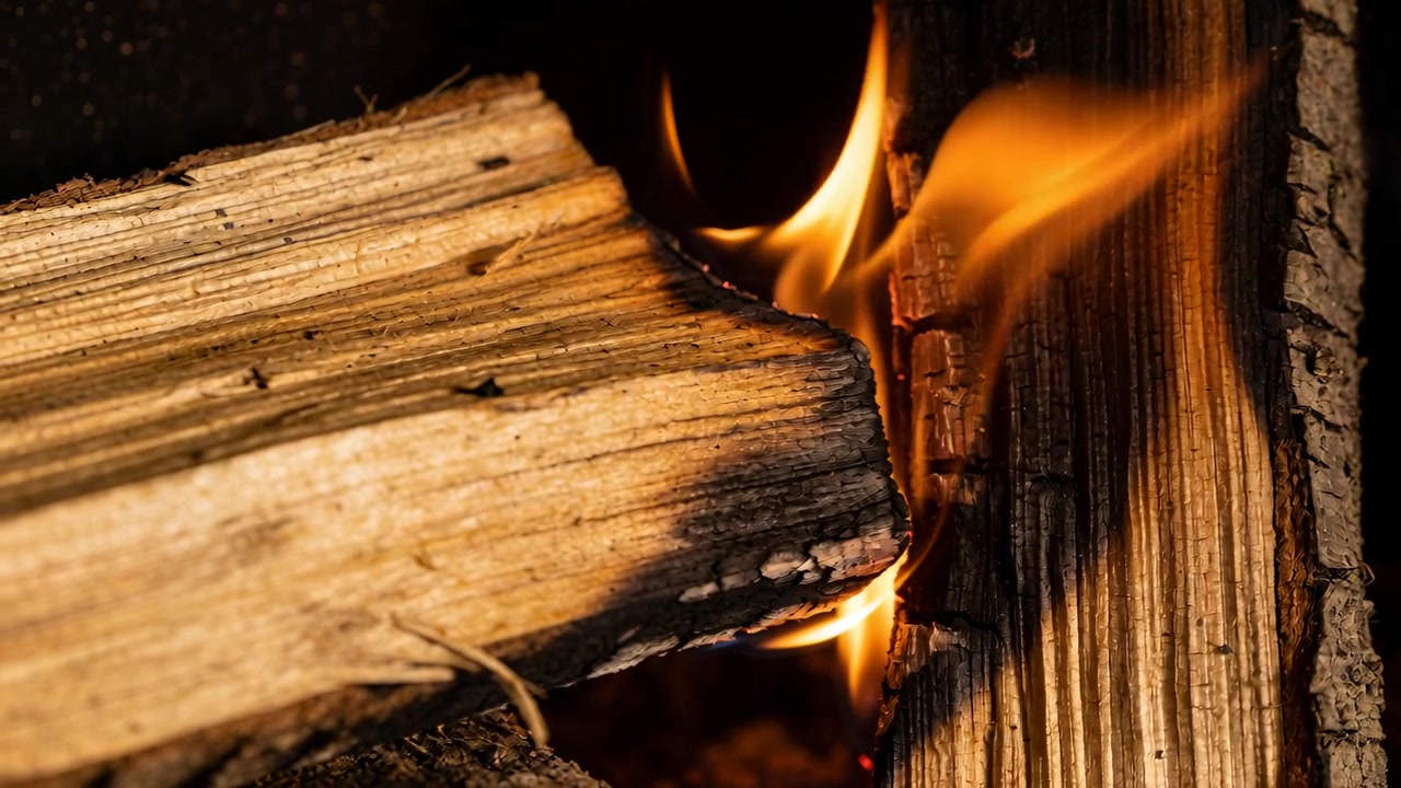 Bara Api Berpijar yang Memercik Menyalakan Celah Kayu Bakar Terbelah, Membakar dan Menghanguskan Serat Kayu di Dalam Perapian Gelap