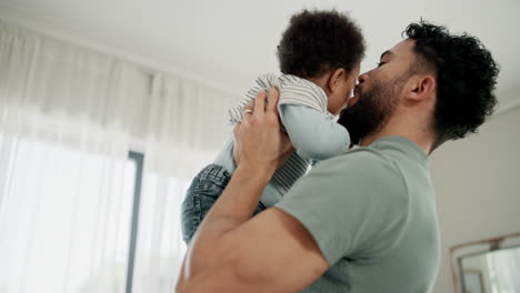 un padre sosteniendo a su hijo bebé
