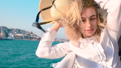 slow motion:beautiful girl enjoys moment while cruising with view of sea on background