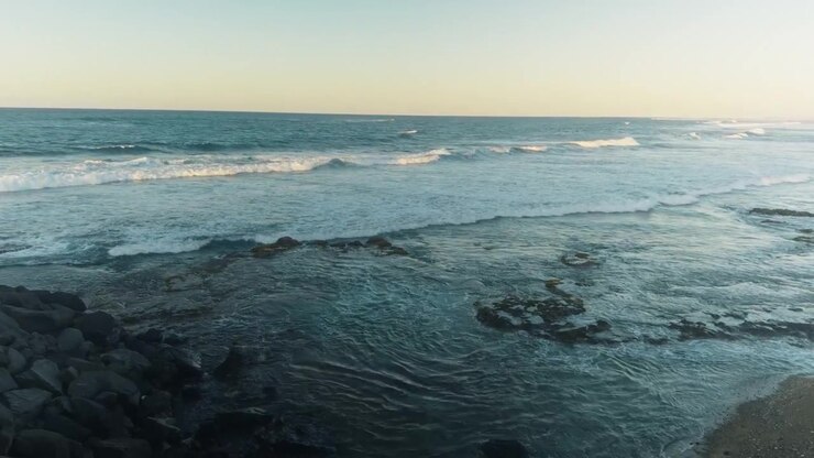 Onde serali si estendono lungo una costa rocciosa caraibica a Porto Rico.