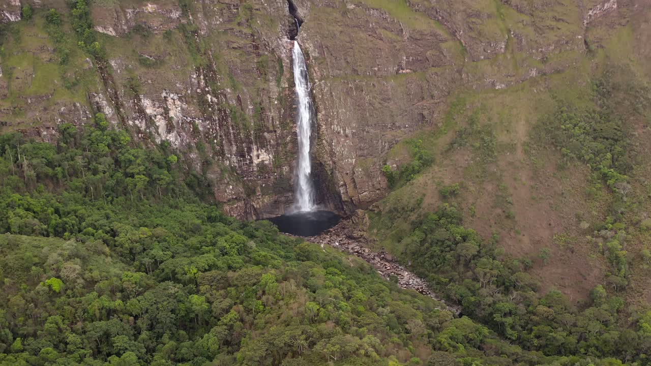 Tall waterfall flowing into a natural pool in Serra da Canastra, Brazil, aerial view
