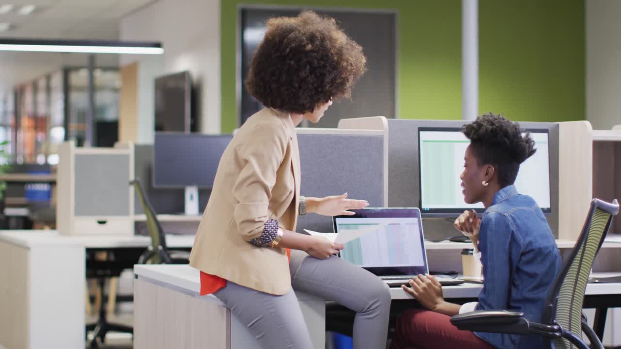 Video of diverse businesswomen working on project and using laptop