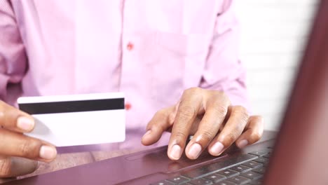 hombre usando tarjeta de crédito en la computadora portátil para comprar en línea