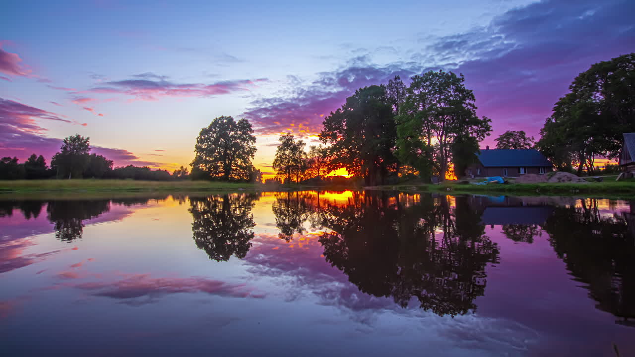 해질녘에 나무 오두막 앞 호수의 전망을 배경으로 일몰의 타임랩스 샷