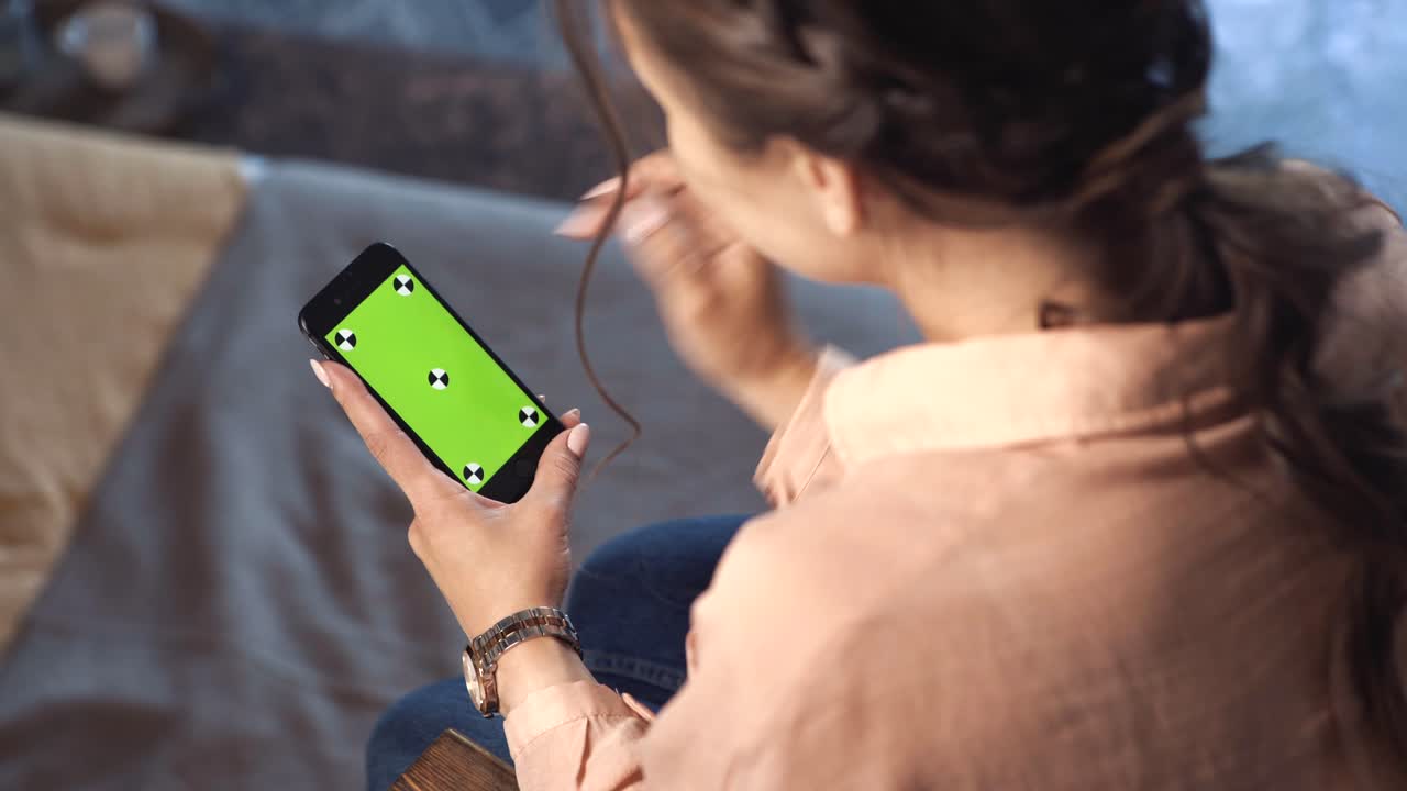 mujer usando un teléfono con una pantalla verde