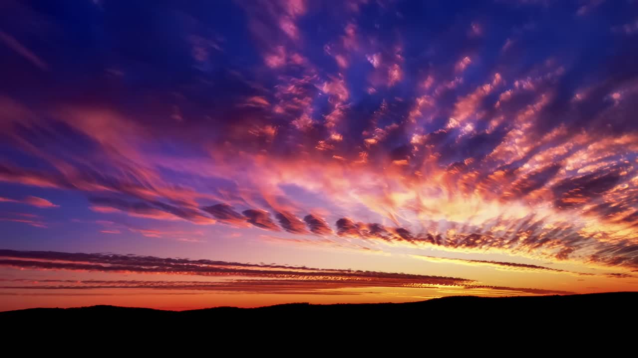 Cielo al atardecer vibrante con nubes espectaculares, capturado en un ángulo de cámara amplio, ideal para vídeo