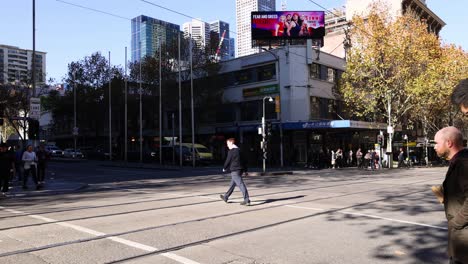 pedestrians crossing a busy intersection in melbourne