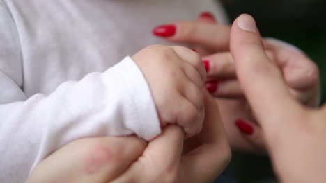 caring mother with baby, concept of love and family. hands of mother and baby closeup, hand in hand. mother care. playing with baby at home. slow motion