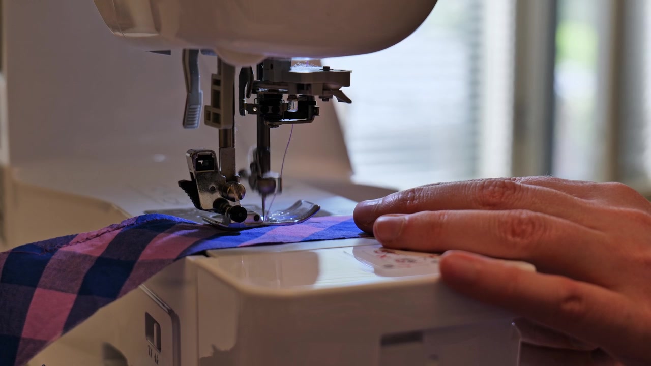 Close up view of tailor using sewing machine