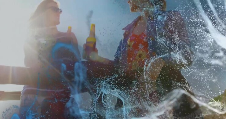 Beverage marketing showing particles dissipating to reveal friends toasting beer bottles on terrace