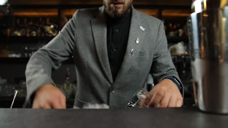bartender preparing an ice-filled cocktail glass