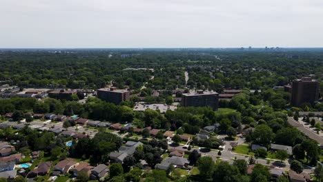 Flying-towards-apartment-buildings-and-homes-in-London,-Ontario-on-a-sunny-day