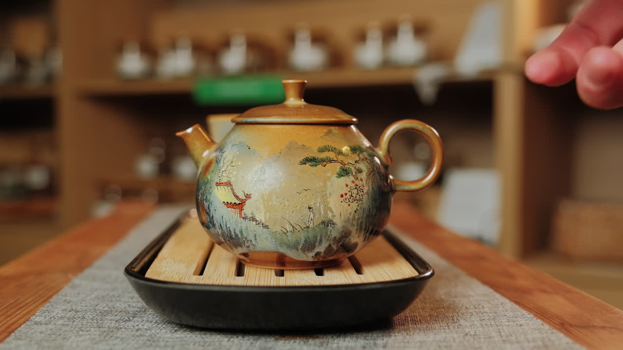 persona sosteniendo una hermosa olla de té pintada