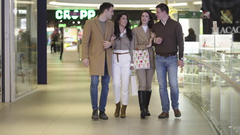 a group of friends walking and shopping in a mall