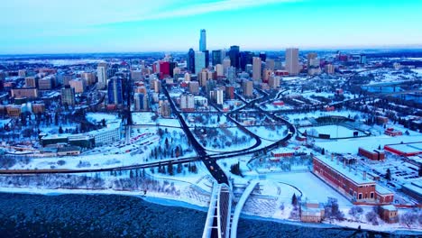 Panorámica-Aérea-De-Invierno-De-4k-Desde-La-Ciudad-De-Edmonton-Cubierta-De-Nieve-Sobrevuelo-Inverso-Vista-De-Pájaro-Del-Icónico-Puente-De-Proa-De-Walter-Dale-Que-Va-De-Norte-A-Sur-Dolly-Roll-Río-Hielo-Piezas-Redondas-Entre-Parientes