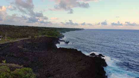 Solitary-house-and-road-near-black-cliffs-on-south-east-hawaii-island-at-sunset