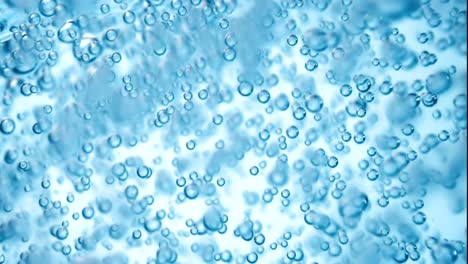 muchas burbujas de agua en agua azul de cerca, onda de agua abstracta con burbujas en cámara lenta.