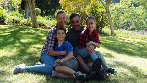 Portrait-of-happy-family-sitting-in-park-4k