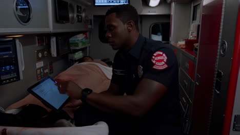 a firefighter using a tablet in an ambulance