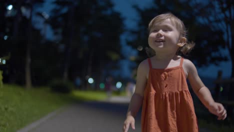 adorável menina ativa de 2 anos no parque à noite - tiro médio