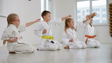 Niños-Arrodillados-En-El-Suelo-En-Clase-De-Artes-Marciales