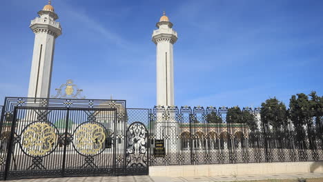 the entrance to a tunisian mausoleum with ornate gates and tall minarets under a blue sky