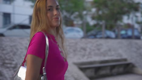 Smiling-Woman-Strolling-Down-the-Street,-Locking-Eyes-with-the-Camera