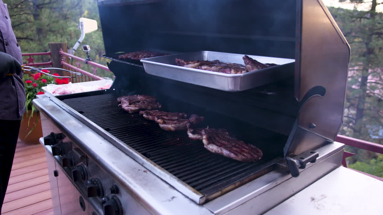 hombre asando bistecs a la parrilla