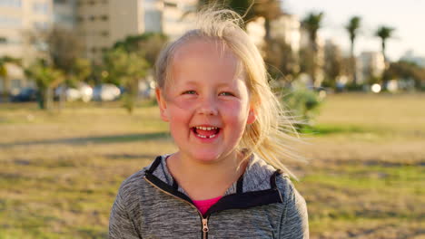 Niño,-Riendo-Y-Cara-Y-Cabello-Ventoso-En-La-Ciudad