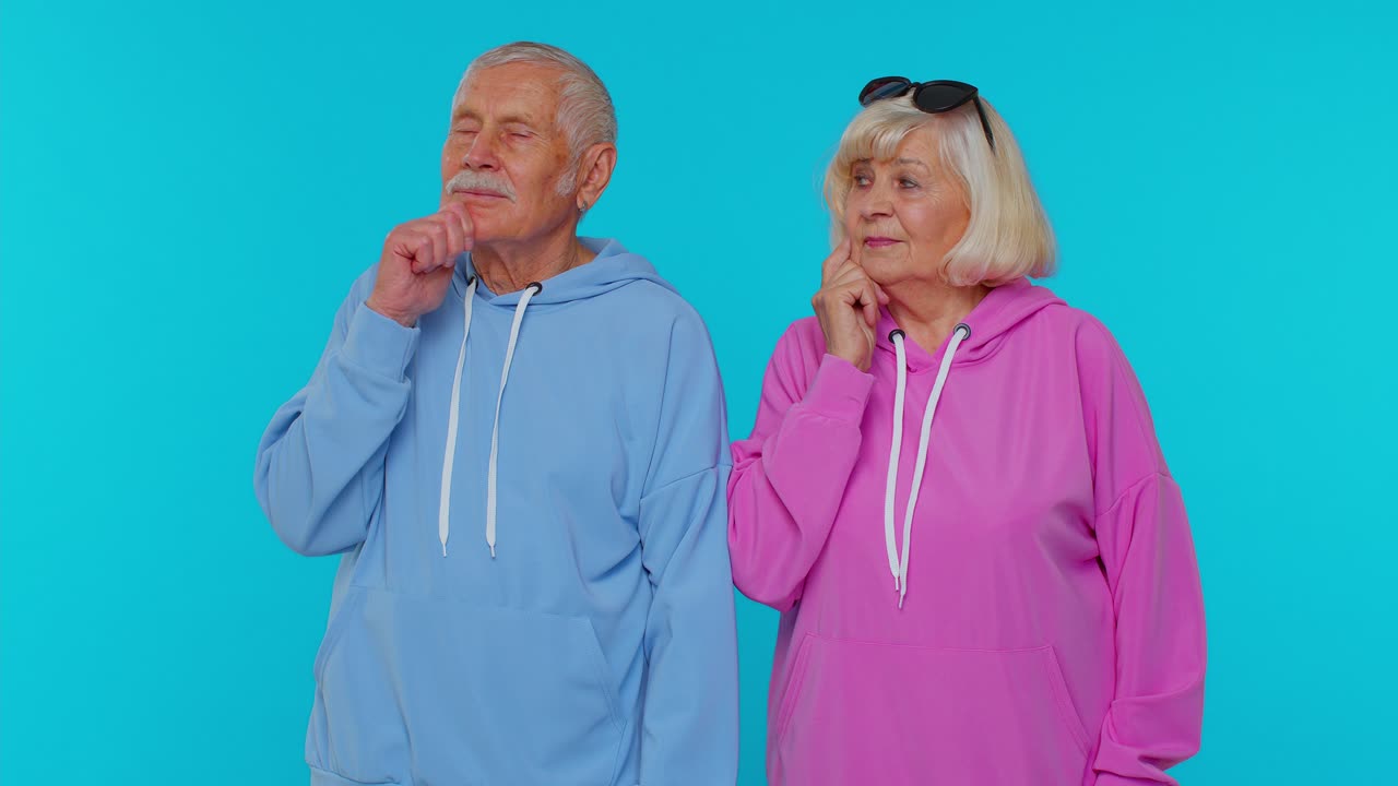 할아버지와 함께 영감을 받은 고령 할머니는 손가락을 높이 가리키고 입을 열고 유레카 제스처를 보여줍니다.