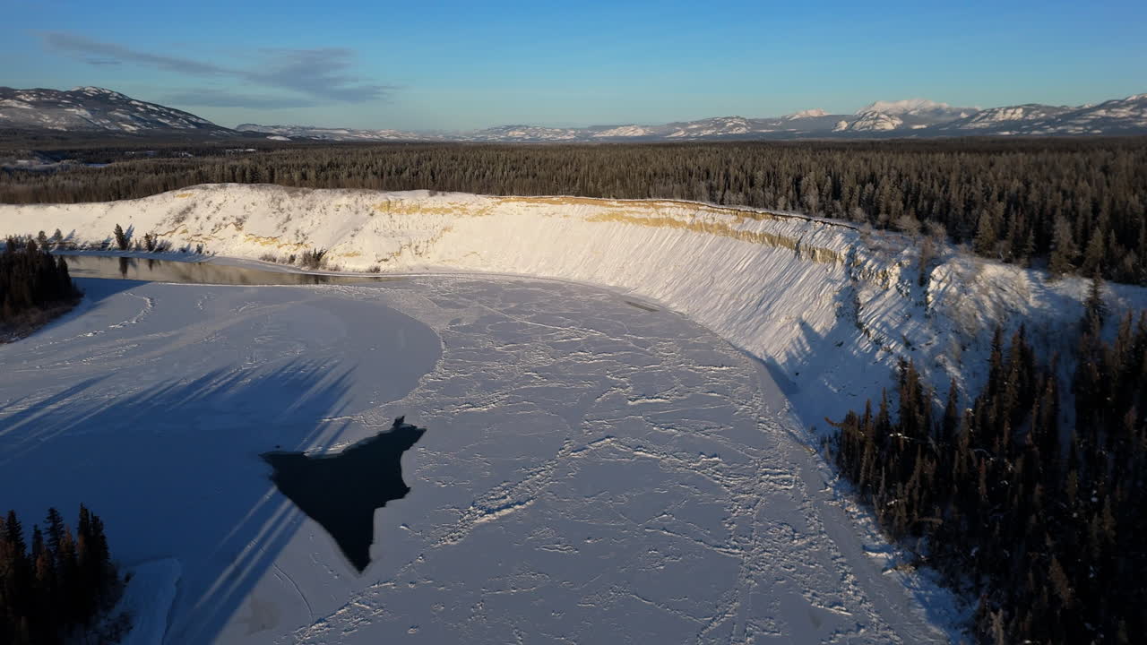 Volando sobre el lago Laberge durante el invierno en Yukón, Canadá - Toma de dron