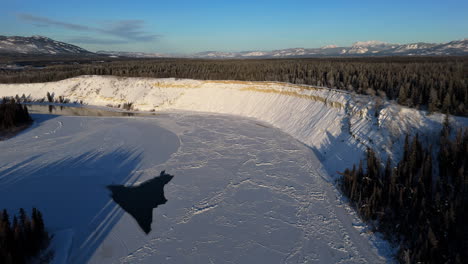 flying above lake laberge during winter in yukon, canada - drone shot