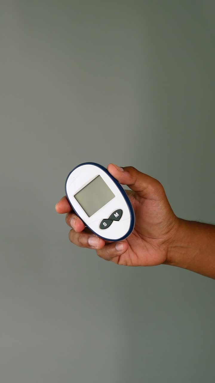 Close-up of Hand Holding a Glucose Meter