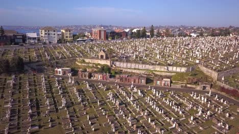 flying over green cemetery in the suburb of australia with construction project in the scene, reverse shot.