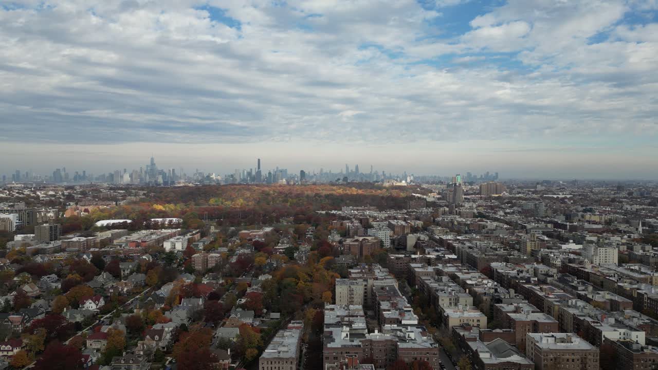 Overhead drone shot of narrow Brooklyn streets framed by bright trees and small homes. A peaceful fall day with red and orange leaves creating a beautiful pattern from above
