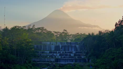 watu purbo waterfall with merapi volcano in background, aerial view
