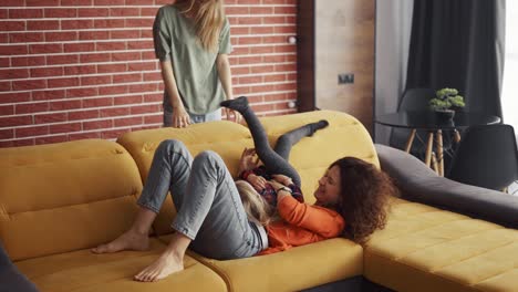 Mothers-are-playing-with-blondy-small-girl-in-the-living-room