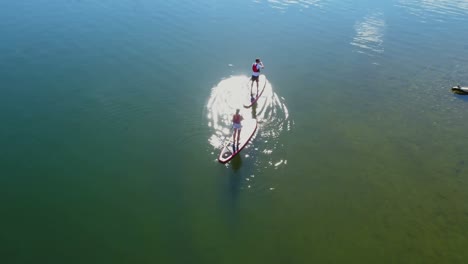 Couple-on-stand-up-paddle-board-oaring-in-river-4k