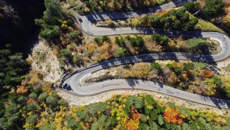 amazing drone view of roadway in mountains covered with lush autumn foliage