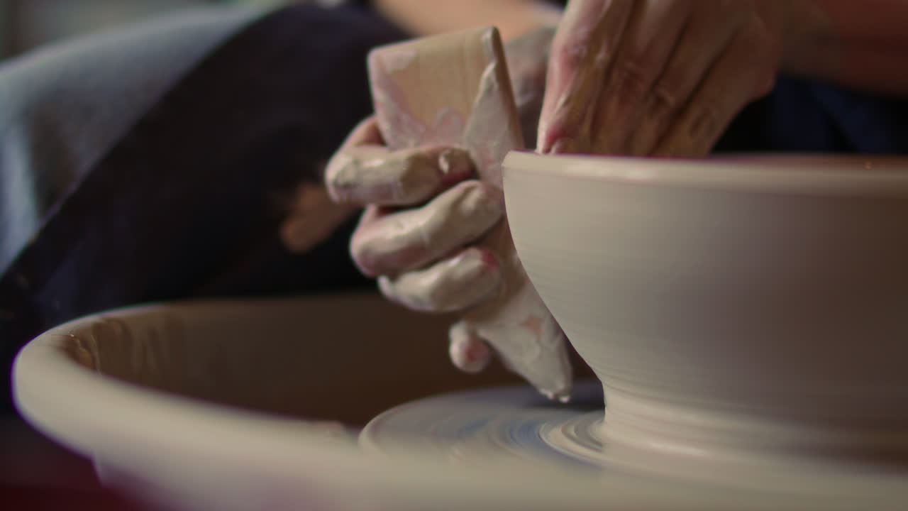 Close Up of Smoothing Clay Bowl with Wooden Rib on Spinning Pottery Wheel