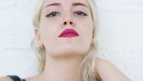 una joven rubia seria mirando fijamente a la cámara