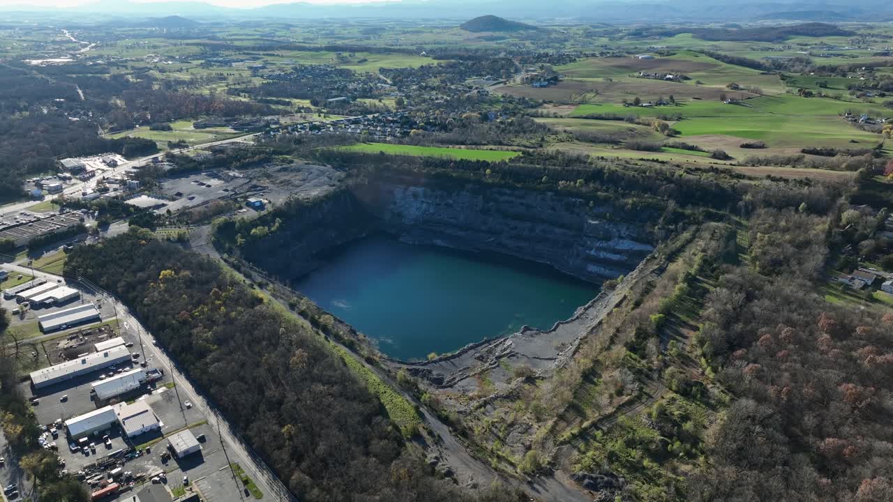 Aerial approaching shot of lake near Frazier Quarry in suburb of Harrisonburg, Virginia. New developed housing units around lake. Wide shot.